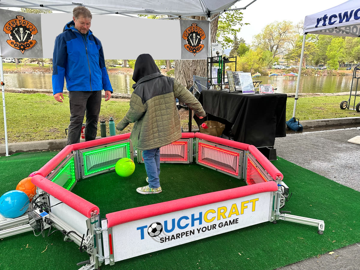 A Touchcraft arena set up at an outdoor community event, a player mid-game
